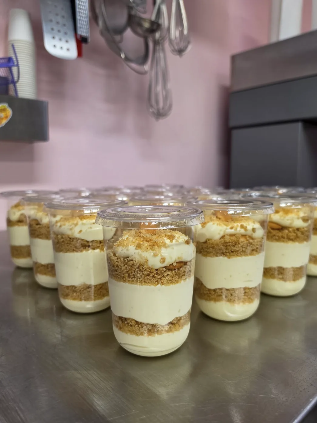 Banana pudding cups topped with rainbow sprinkles, lined up in the case